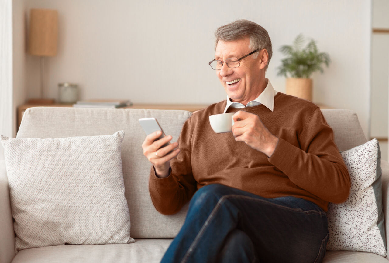 Pensionado feliz usando su celular
